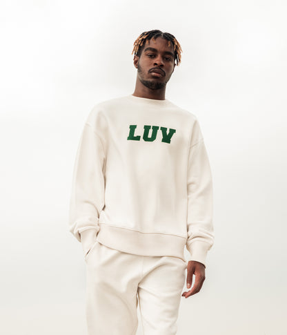 Man wearing the Freshman Sweatshirt in Natural with forest green LUV graphic